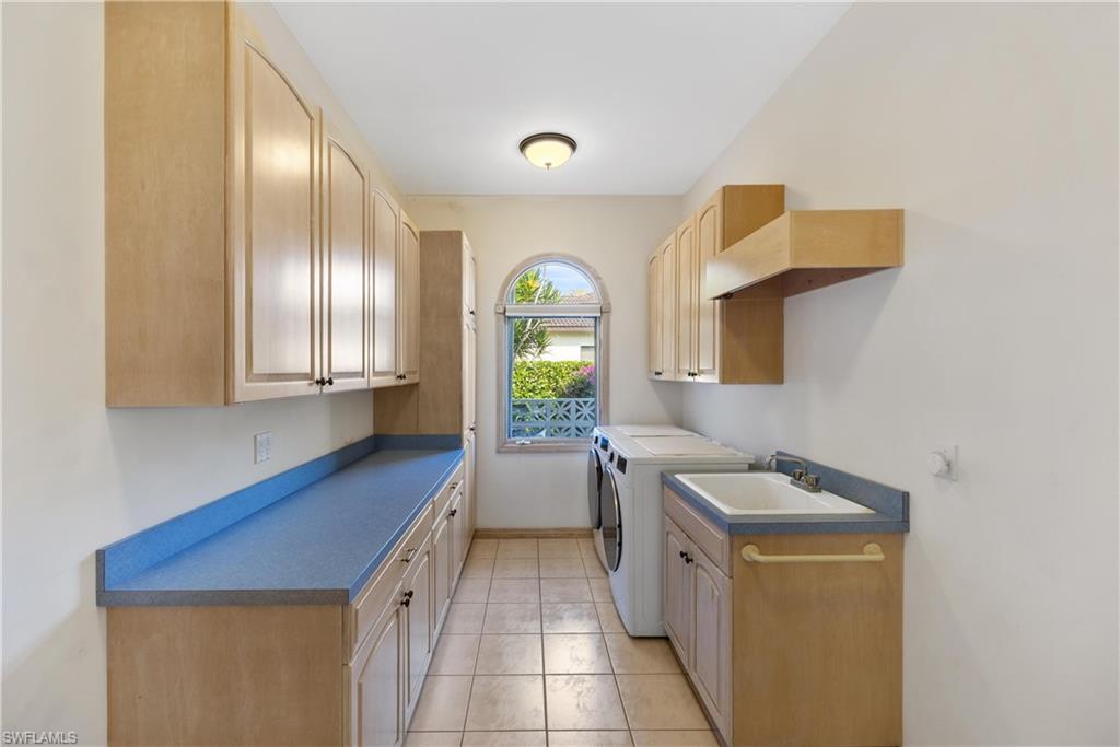 8992 Lely Island Circle Naples, FL 34113 - Photo 32 of 42 a kitchen with a sink a counter top space and cabinets