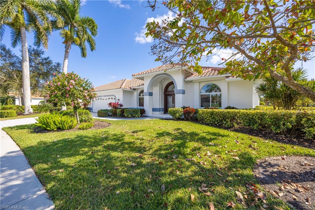 8992 Lely Island Circle Naples, FL 34113 - Photo 8 of 42 a front view of a house with a yard and garage
