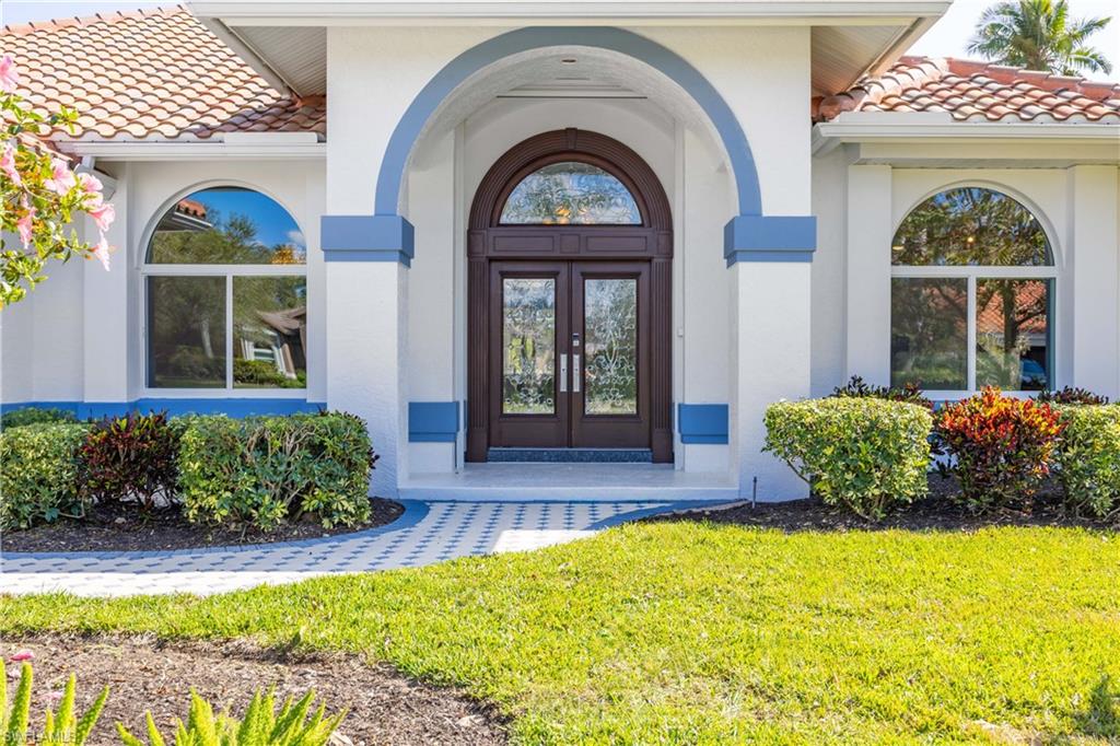 8992 Lely Island Circle Naples, FL 34113 - Photo 9 of 42 a front view of a house with garden