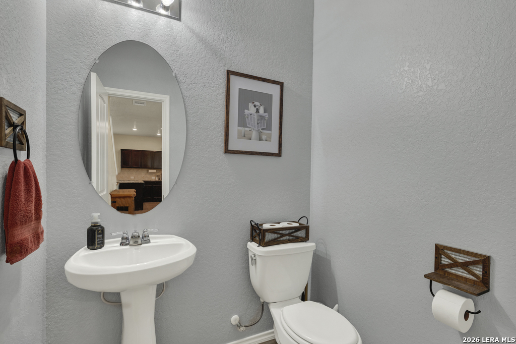 124 Field Ridge New Braunfels, TX 78130 - Photo 16 of 43 a bathroom with a toilet a sink and mirror