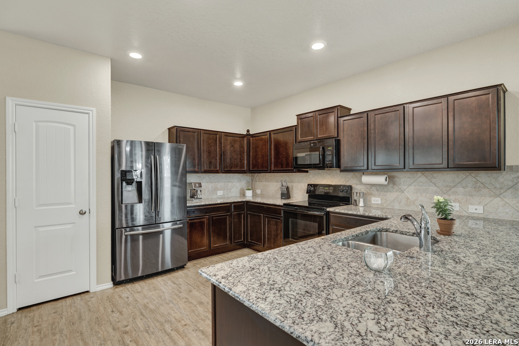 124 Field Ridge New Braunfels, TX 78130 - Photo 7 of 43 a kitchen with granite countertop a refrigerator and a stove top oven