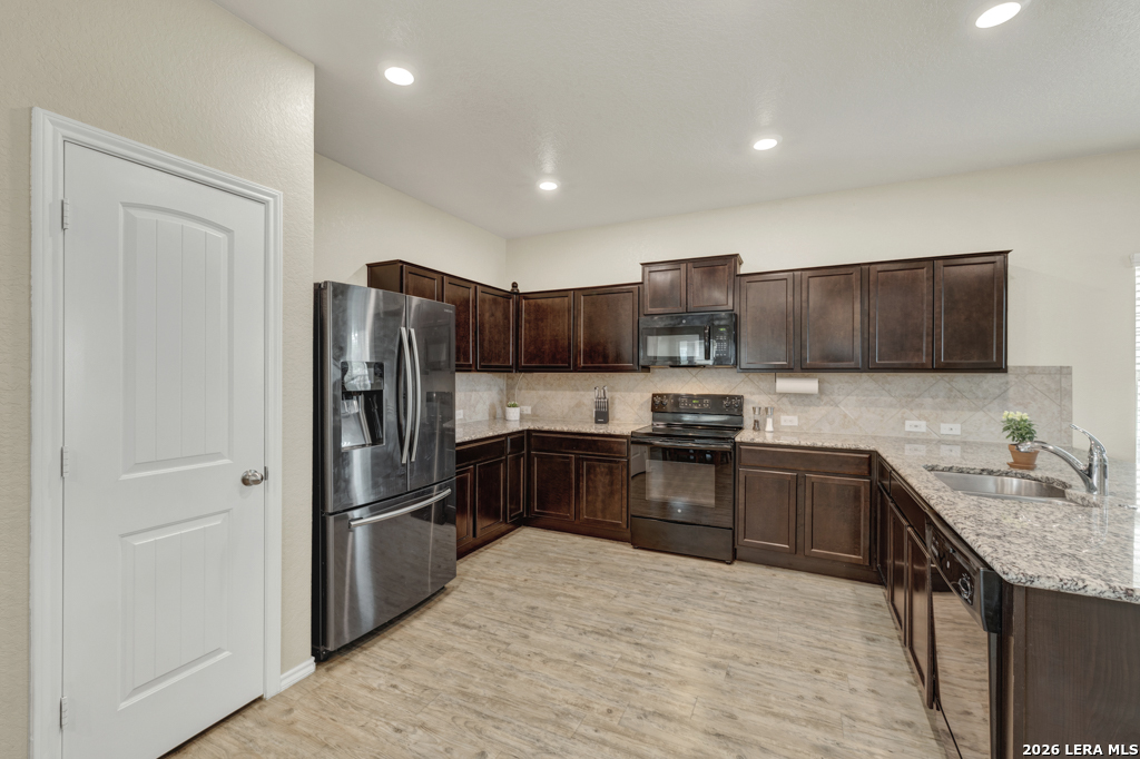 124 Field Ridge New Braunfels, TX 78130 - Photo 8 of 43 a kitchen with granite countertop stainless steel appliances and wooden cabinets