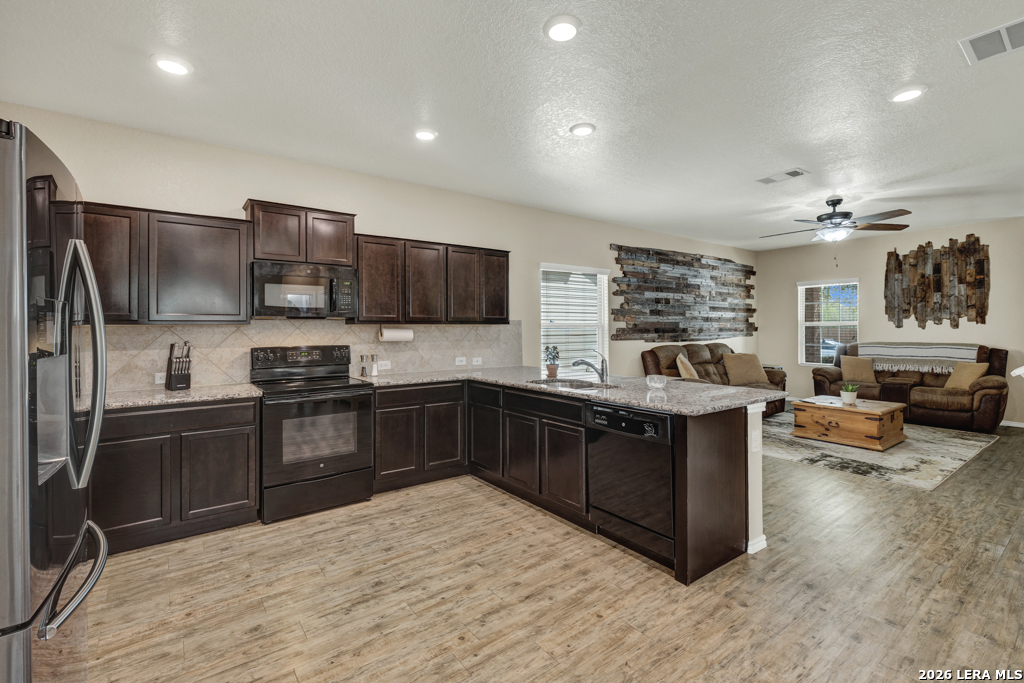 124 Field Ridge New Braunfels, TX 78130 - Photo 9 of 43 a kitchen with stainless steel appliances kitchen island granite countertop a refrigerator and a stove top oven