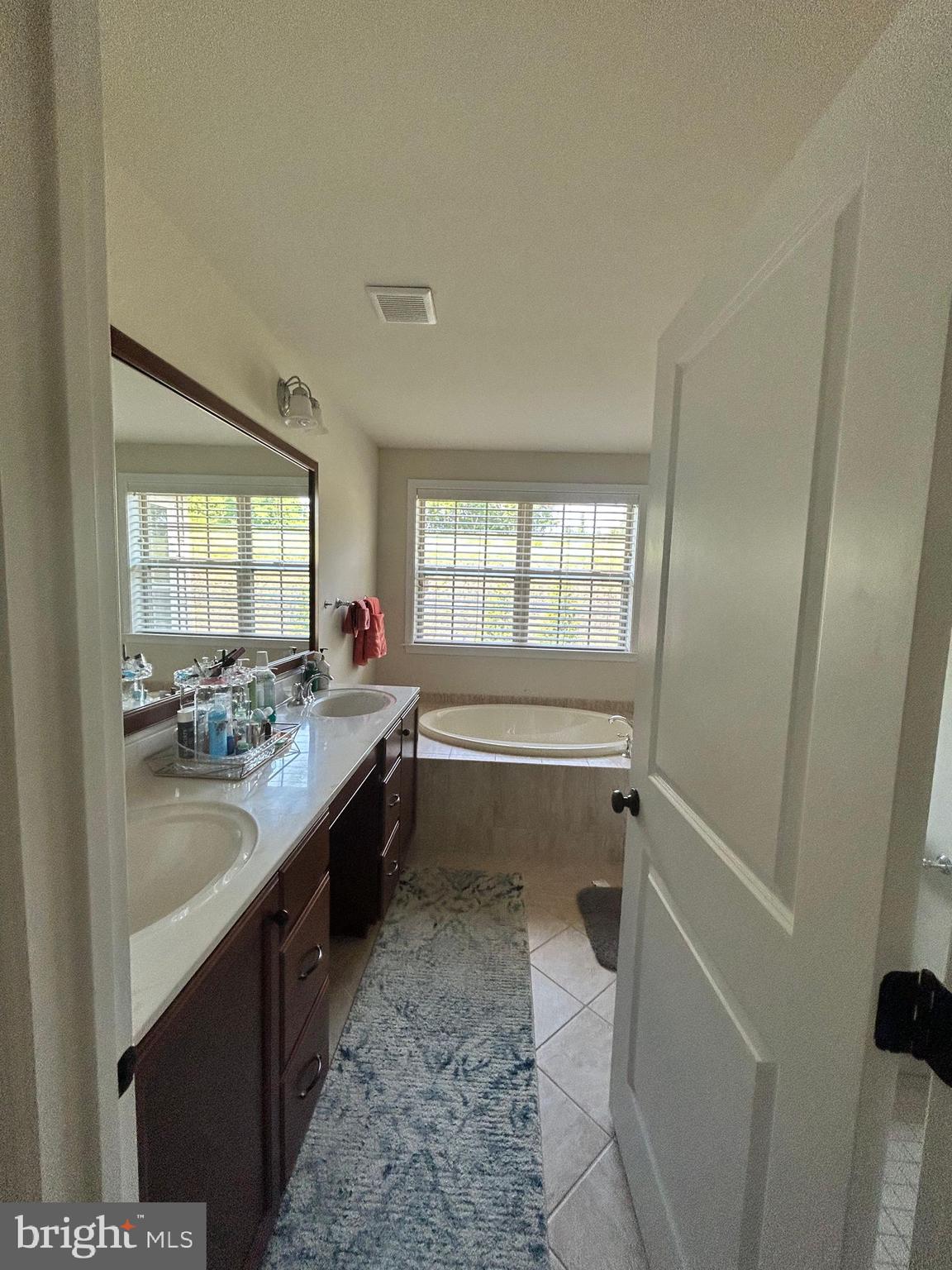 3049 Rainer Road Chester Springs, PA 19425 - Photo 8 of 19 a large bathroom with a granite countertop tub a sink and a large window