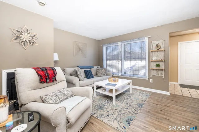 a dining room with wooden floor a chandelier fan a wooden table and chairs