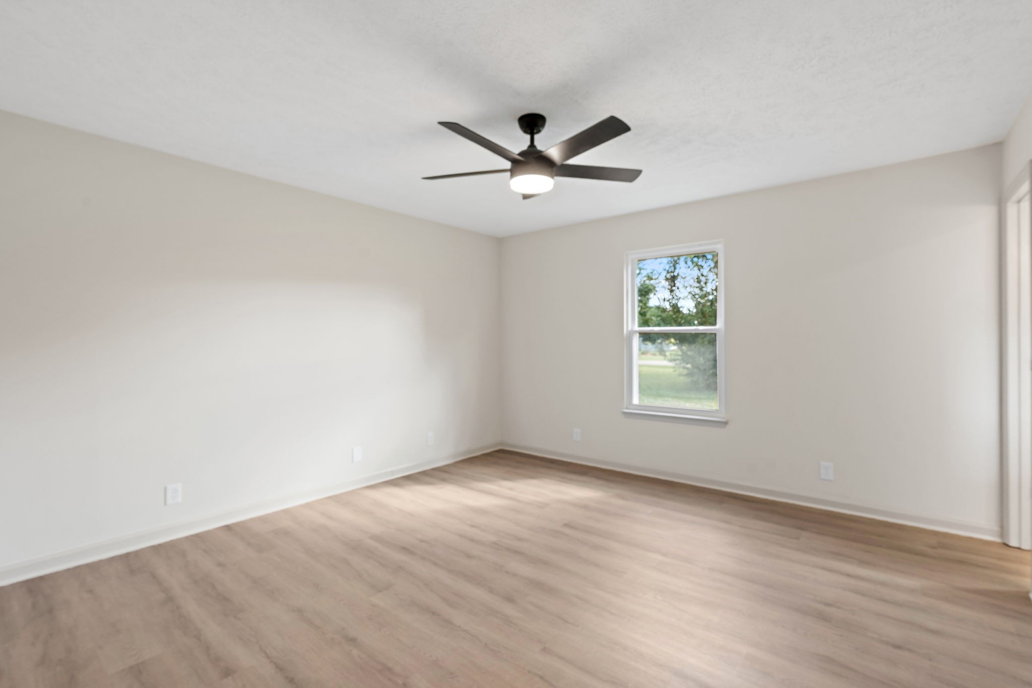 583 Parsons Road Christiana, TN 37037 - Photo 22 of 35 an empty room with wooden floor a ceiling fan and windows