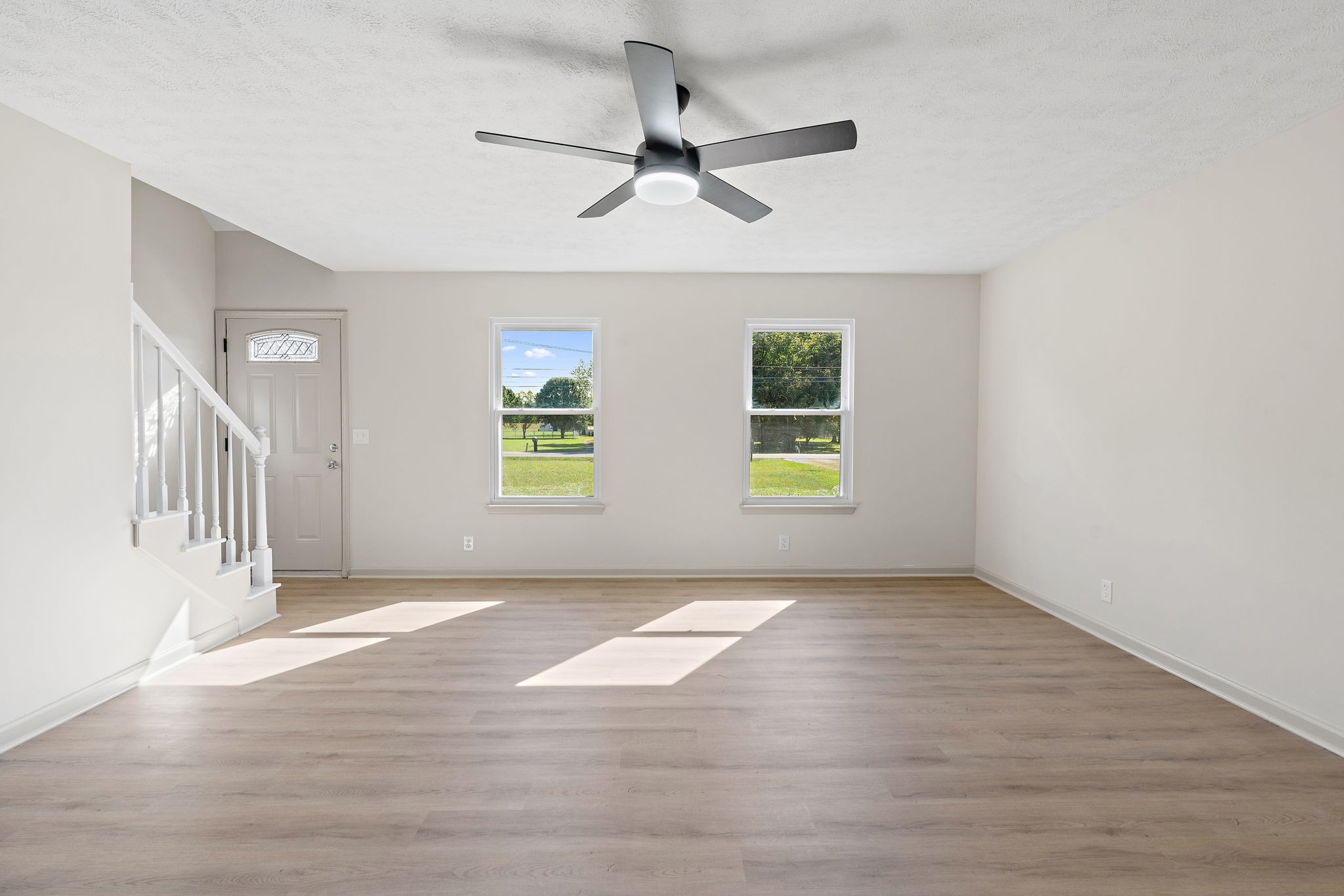 583 Parsons Road Christiana, TN 37037 - Photo 9 of 35 an empty room with wooden floor ceiling fan and windows