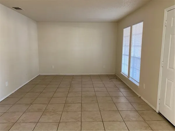 en empty room with white walls and tiles