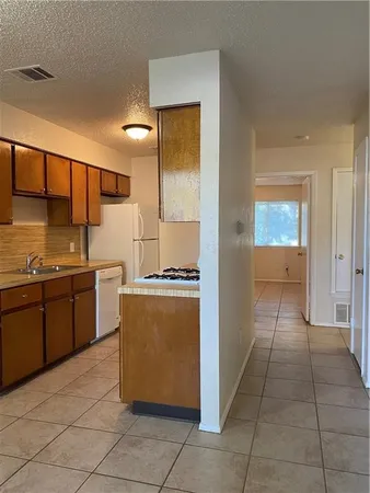 a kitchen with stainless steel appliances granite countertop a refrigerator and a stove