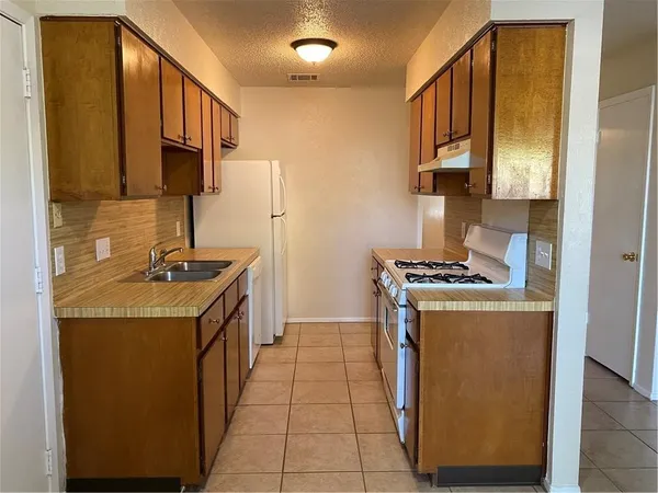 a kitchen with stainless steel appliances granite countertop a stove a sink and a refrigerator