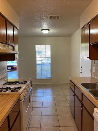 a kitchen with granite countertop a stove and a sink