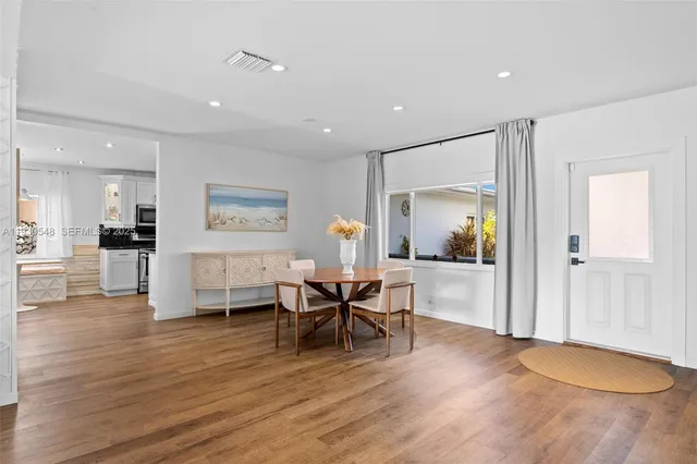 a large kitchen with stainless steel appliances a large counter top a stove a refrigerator and a microwave