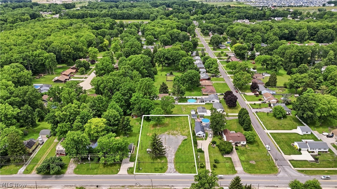 7474 Avon Belden Road North Ridgeville, OH 44039 - Photo 5 of 6 Expansive lot featuring a single evergreen tree, partial paved surface, and generous green space
