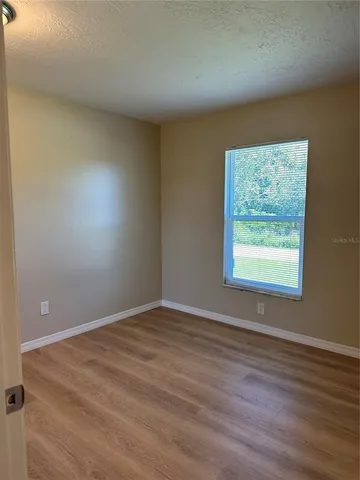 an empty room with wooden floor and closet