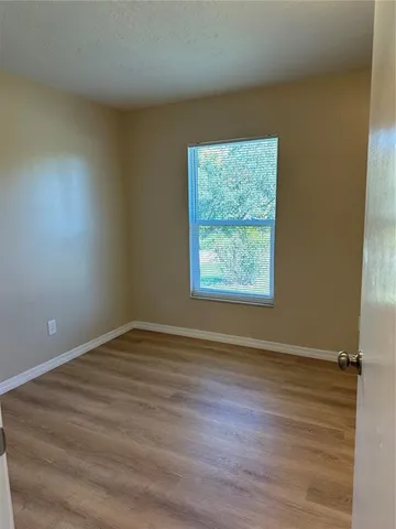 an empty room with wooden floor and entrance
