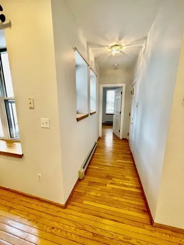 a view of empty room with window and wooden floor