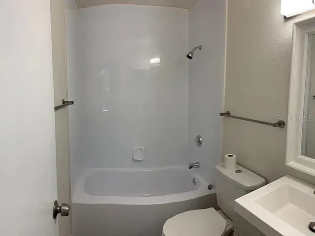 a white bath tub sitting next to a white toilet and sink