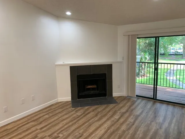 a view of empty room with wooden floor and fireplace