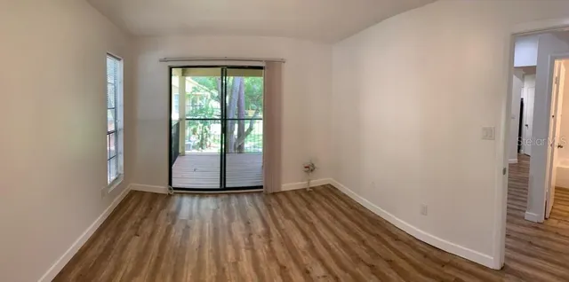 a view of a room with wooden floor and large window