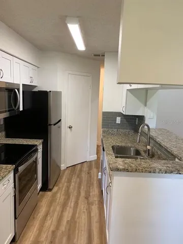 a kitchen with kitchen island granite countertop a stove and a sink