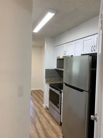 a metallic refrigerator freezer sitting in a kitchen