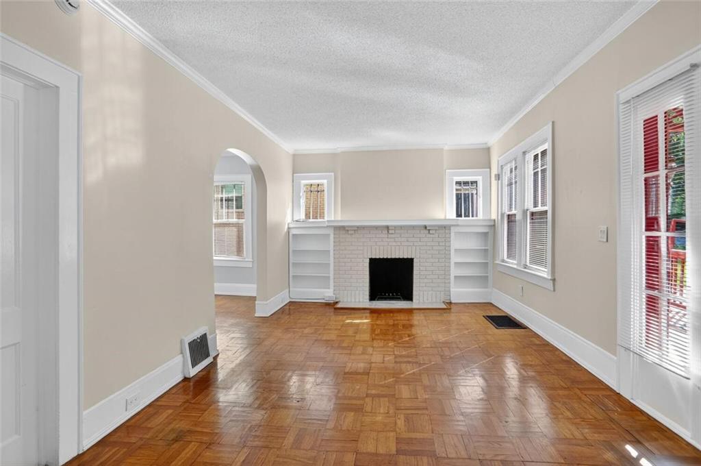 1497 North Morningside Drive Northeast Atlanta, GA 30306 - Photo 18 of 36 a view of empty room with wooden floor and fireplace