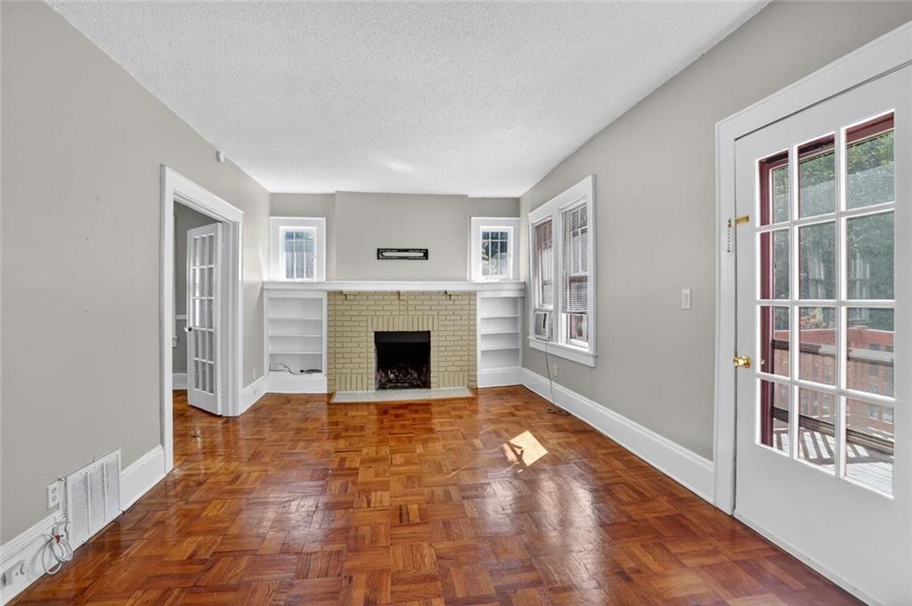 1497 North Morningside Drive Northeast Atlanta, GA 30306 - Photo 4 of 36 a view of empty room with windows and fireplace