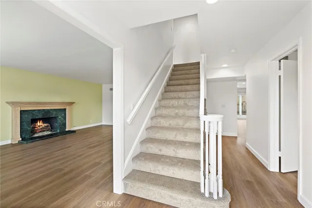 a view of an empty room with wooden floor fire place