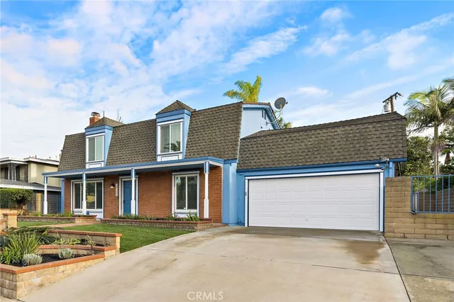 a front view of a house with a garden and plants