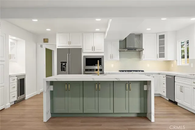 a kitchen with stainless steel appliances granite countertop a sink a stove and a refrigerator