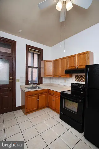 a kitchen with stainless steel appliances granite countertop a stove top oven a sink a counter space and cabinets