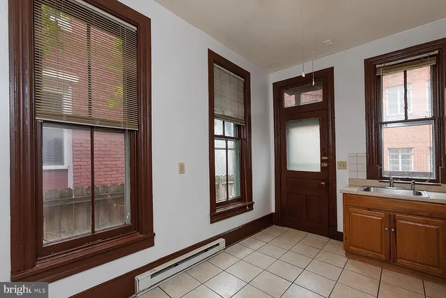 a view of kitchen with windows and refrigerator
