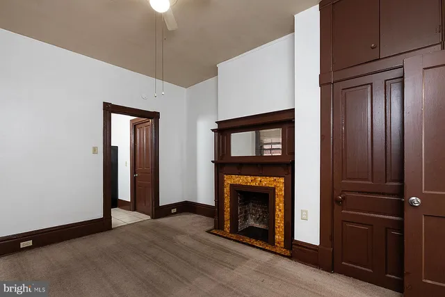 a view of an empty room with wooden floor a fireplace