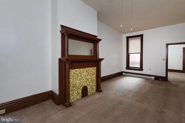 a view of an empty room with a fireplace and a window