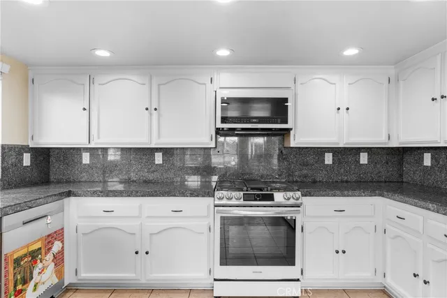 a kitchen with white cabinets stainless steel appliances and sink