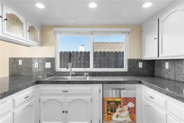 a kitchen with granite countertop a sink and cabinets