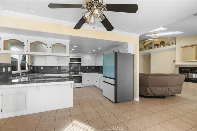 a kitchen with stainless steel appliances kitchen island granite countertop a refrigerator and a sink