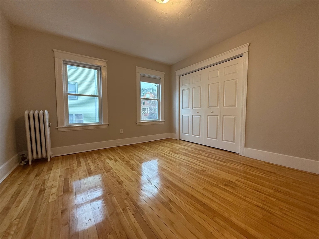 1301 Main Street, Unit 2 Worcester, MA 01603 - Photo 11 of 15 an empty room with wooden floor and windows