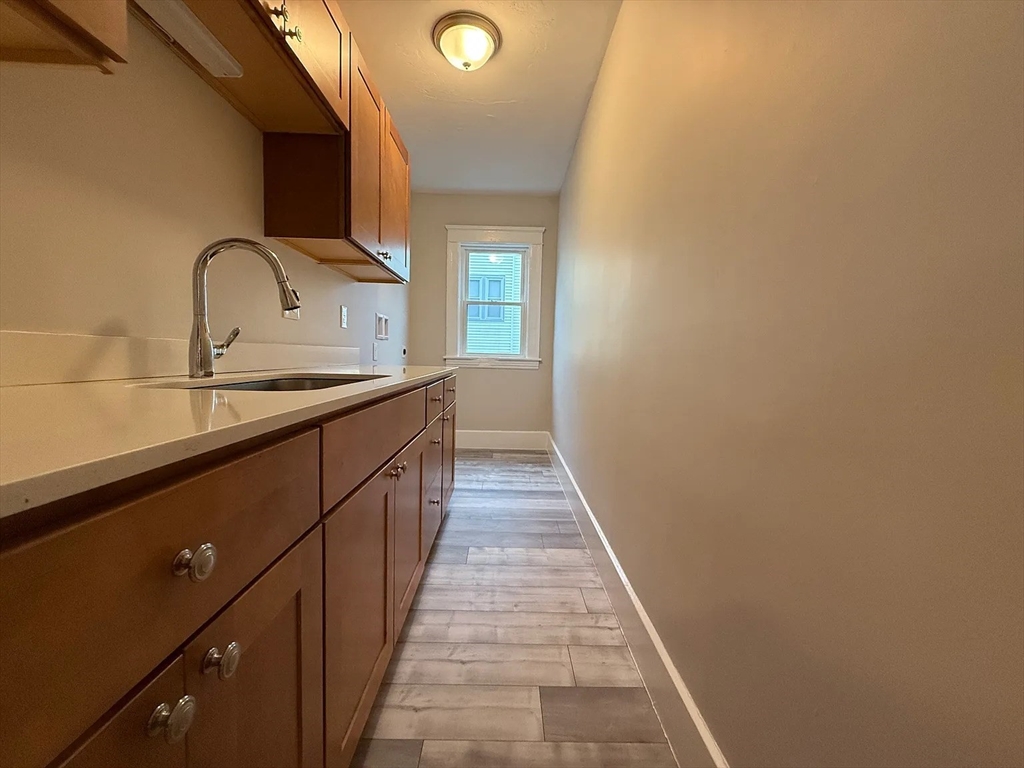 1301 Main Street, Unit 2 Worcester, MA 01603 - Photo 3 of 15 a hallway with a sink and wooden floor