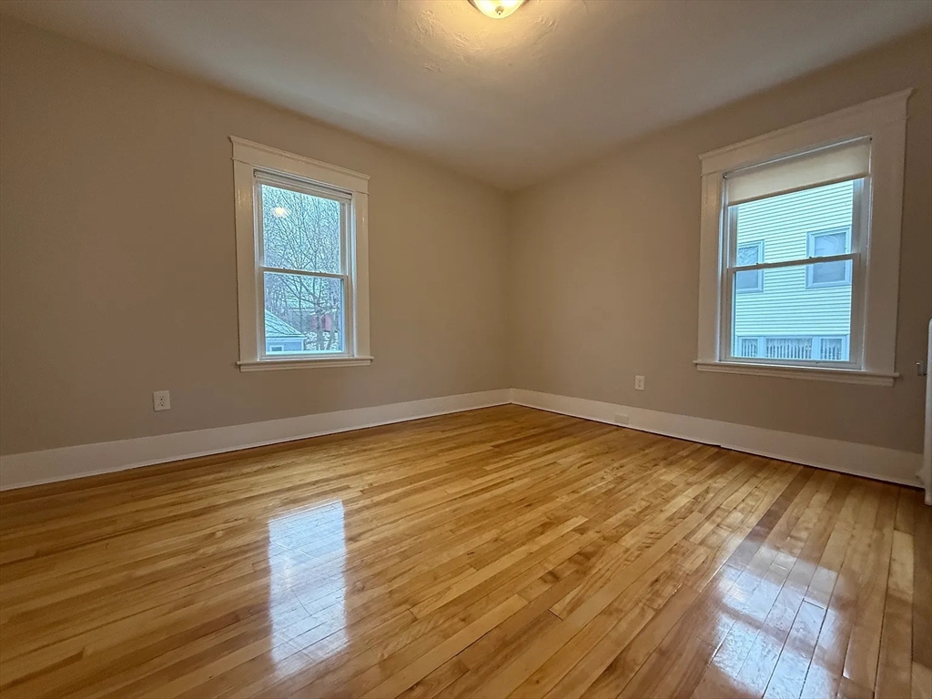 1301 Main Street, Unit 2 Worcester, MA 01603 - Photo 4 of 15 an empty room with wooden floor and windows