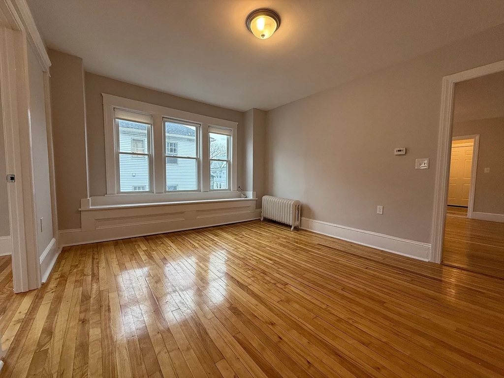 1301 Main Street, Unit 2 Worcester, MA 01603 - Photo 10 of 15 an empty room with wooden floor and windows