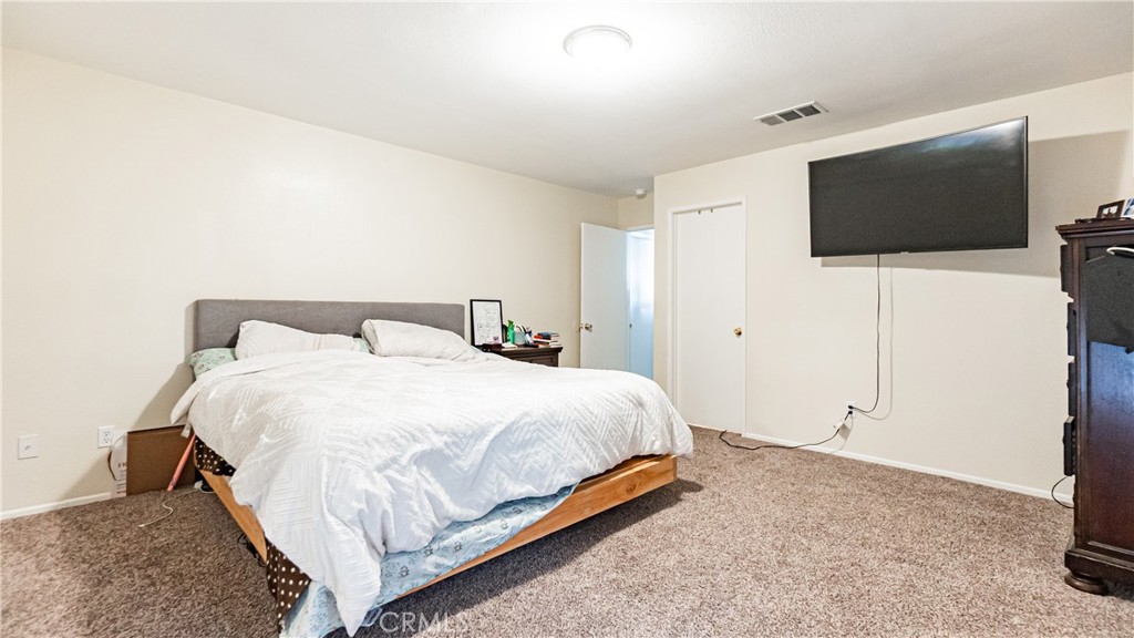 22993 Eyota Road Apple Valley, CA 92308 - Photo 17 of 38 a bedroom with a bed and a flat screen tv