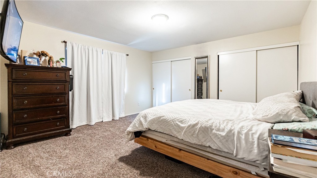 22993 Eyota Road Apple Valley, CA 92308 - Photo 18 of 38 a bedroom with a bed and a television