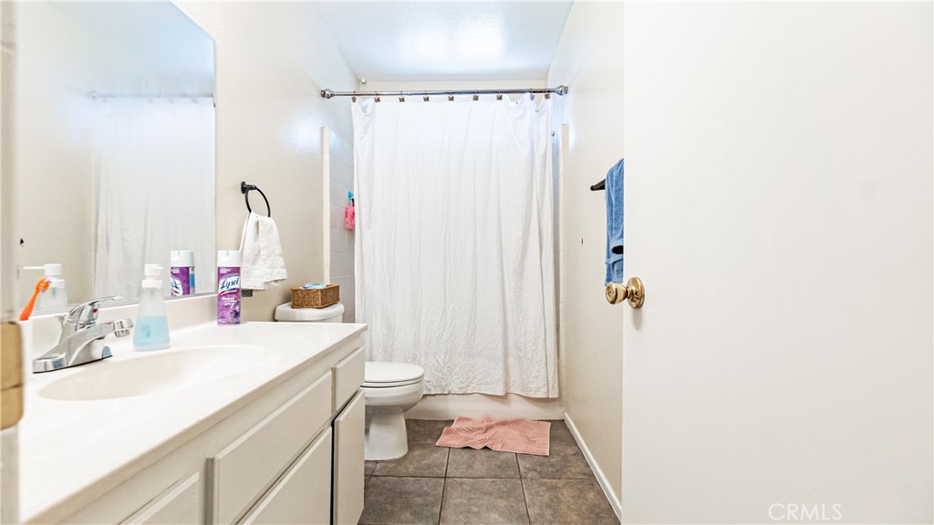 22993 Eyota Road Apple Valley, CA 92308 - Photo 19 of 38 a bathroom with a sink a toilet and shower curtain