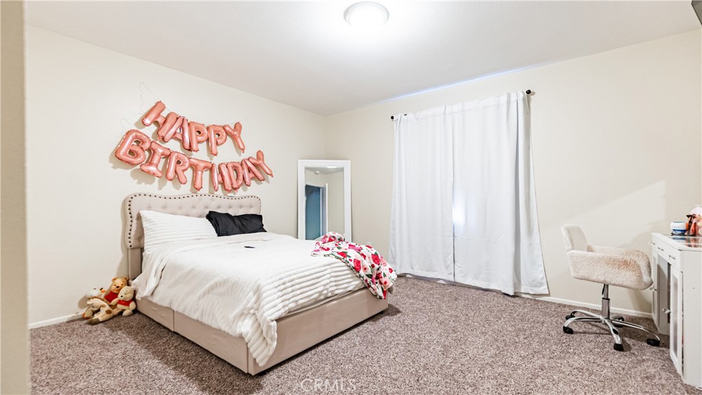 22993 Eyota Road Apple Valley, CA 92308 - Photo 21 of 38 a bedroom with a bed and a chair