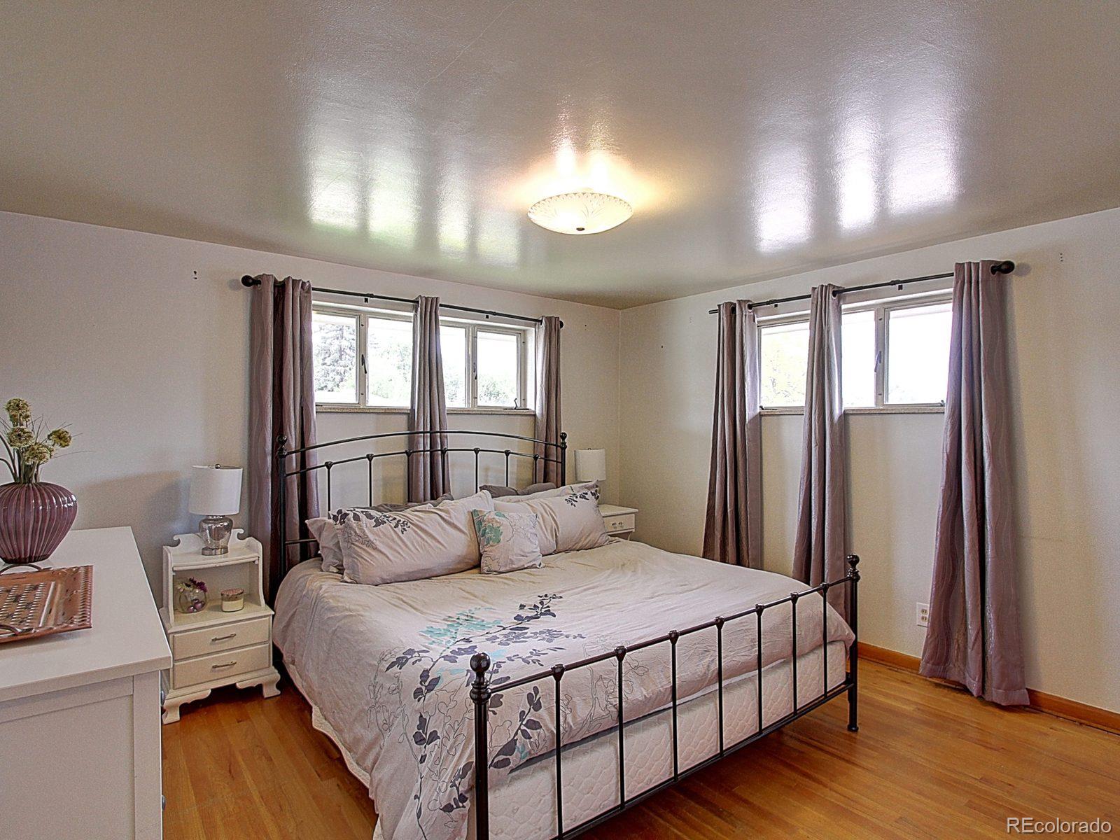 3840 Pierce Street Wheat Ridge, CO 80033 - Photo 14 of 32 a bedroom with a large bed and a window