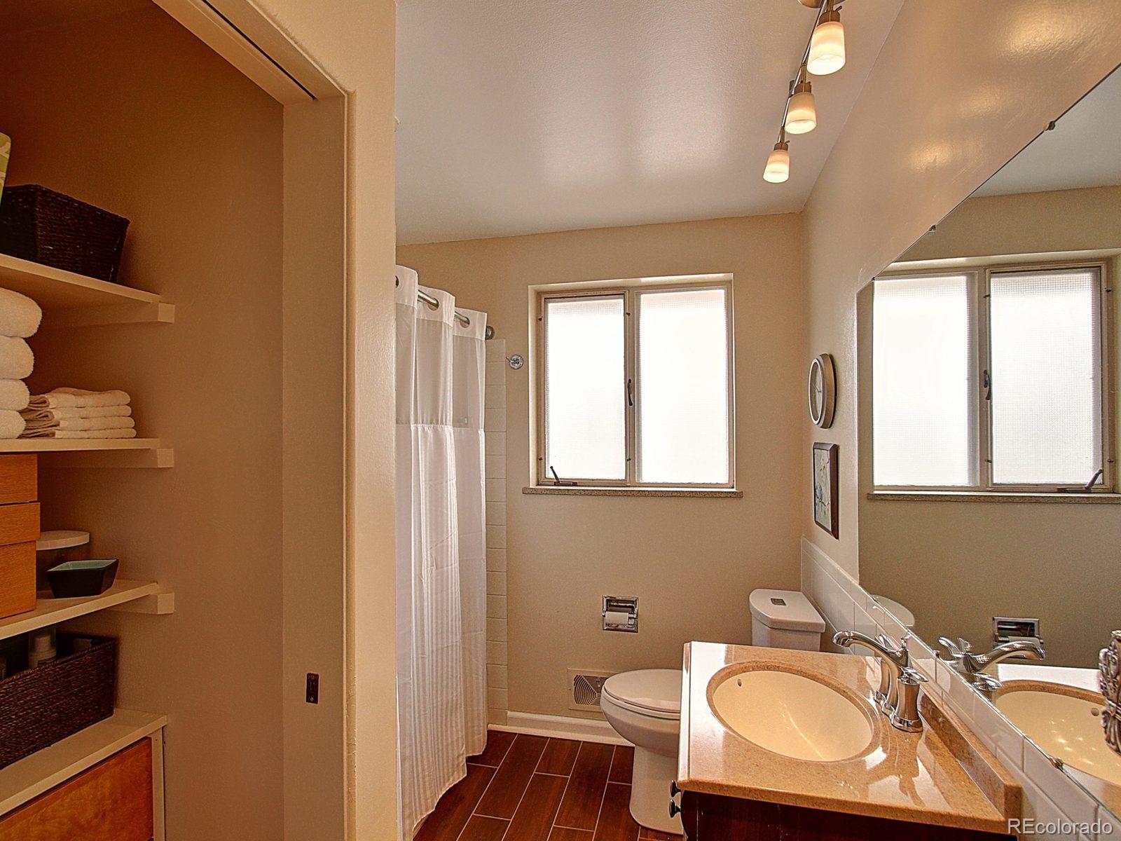 3840 Pierce Street Wheat Ridge, CO 80033 - Photo 17 of 32 a bathroom with a sink a toilet and a mirror