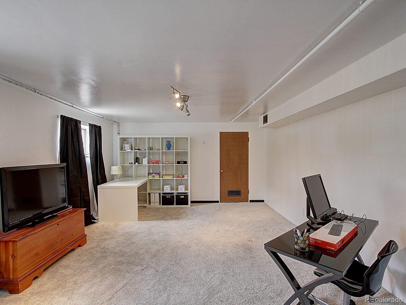 3840 Pierce Street Wheat Ridge, CO 80033 - Photo 19 of 32 a view of a livingroom with furniture and a flat screen tv