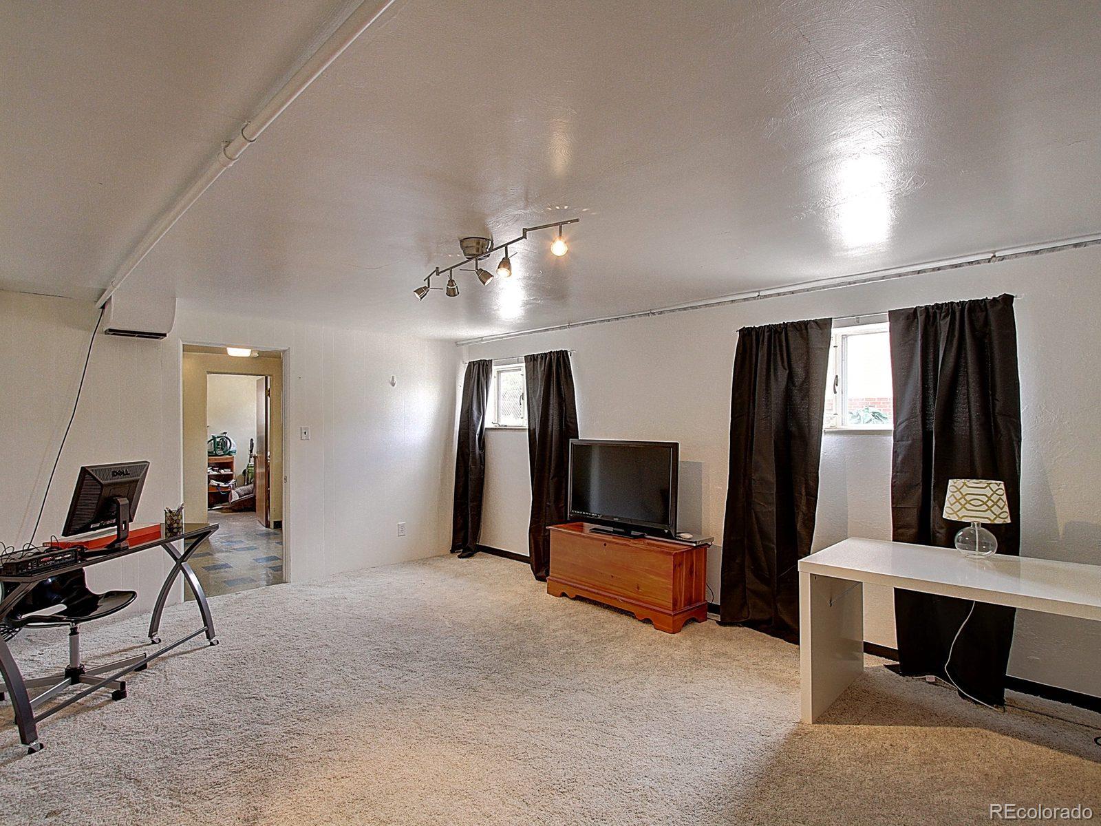 3840 Pierce Street Wheat Ridge, CO 80033 - Photo 20 of 32 a view of a livingroom with furniture and a flat screen tv