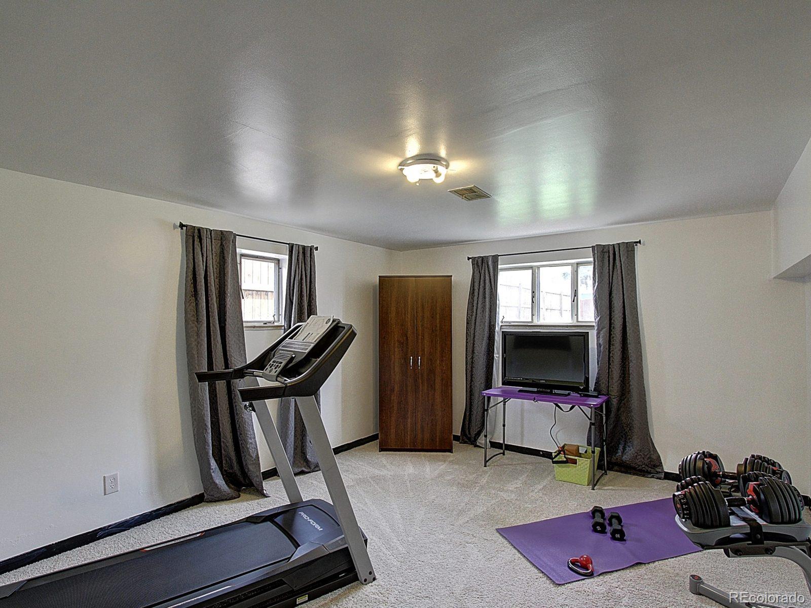 3840 Pierce Street Wheat Ridge, CO 80033 - Photo 21 of 32 a room with gym equipment and a flat screen tv